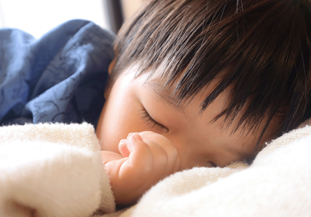 指しゃぶりをしながら眠る子ども